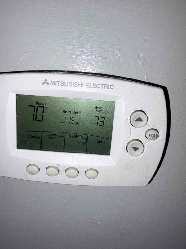 Responded to no heat call where tenant reported blank thermostat. Upon arrival, found Mitsubishi Electric thermostat was operational with display showing 70° indoor temperature and 73° heat setpoint with "Hold Until 2:15 PM" active. Inspected air filter which showed normal dust accumulation but was in serviceable condition. System was functioning properly with no issues found.