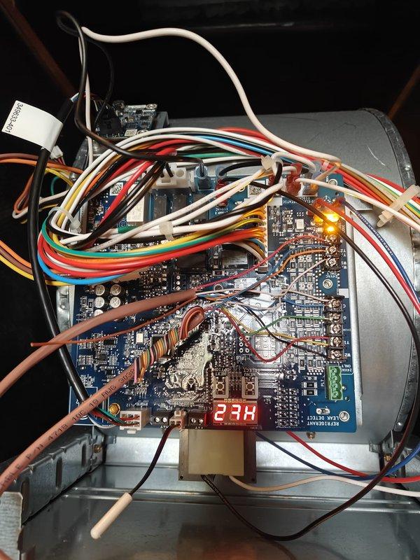 Performed heating maintenance service including system diagnostic testing with readings of 63.7 on temperature differential. Inspected control board circuitry and verified proper operation of electronic components, noting normal function of the digital display (23H) and all connection points. All colored wiring harnesses were examined and confirmed to be properly secured with no signs of wear or damage.