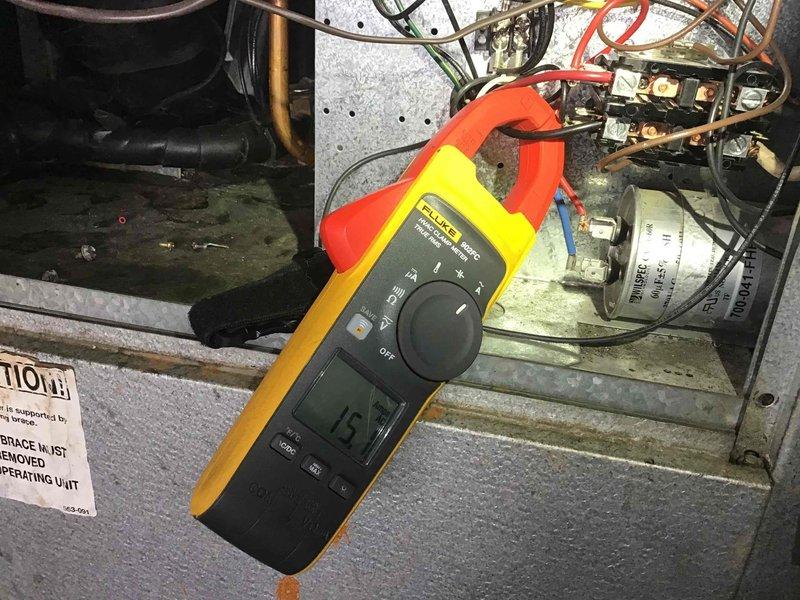 Conducted diagnostic assessment of HVAC system, including detailed inspection of heat exchanger coil/condenser components. Performed electrical testing using clamp meter, recording 15-amp reading on main circuit. Documented condition of internal components showing normal dust accumulation and minor wear consistent with system age.