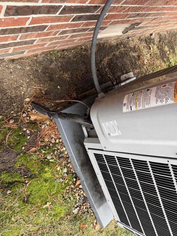 Conducted scheduled tune-up service on outdoor air conditioning condenser unit mounted against brick wall. Performed electrical system diagnostics using SC260 multimeter, which registered 182V at the control board. Inspected all components including capacitors, wiring connections and electrical harnesses, confirming proper operation of the system.