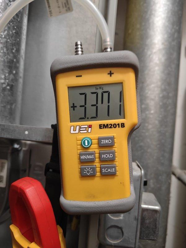 Performed preventative maintenance on furnace system at rental property. Conducted static pressure testing with UEi EM201B manometer, recording a reading of +3.377 In.Wg. Inspected water heater installation and associated ductwork, noting proper configuration of galvanized metal ducts, insulated pipes, and expansion tank.