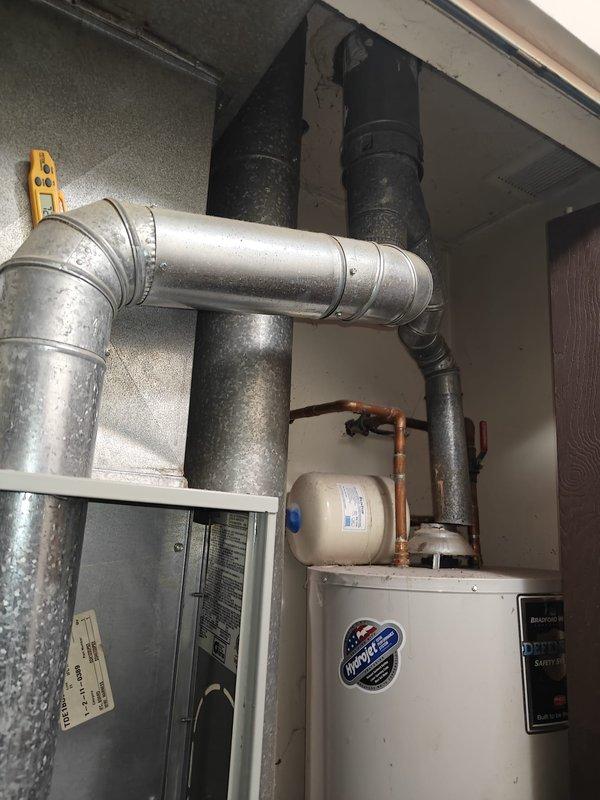 Performed preventative maintenance on furnace system at rental property. Conducted static pressure testing with UEi EM201B manometer, recording a reading of +3.377 In.Wg. Inspected water heater installation and associated ductwork, noting proper configuration of galvanized metal ducts, insulated pipes, and expansion tank.