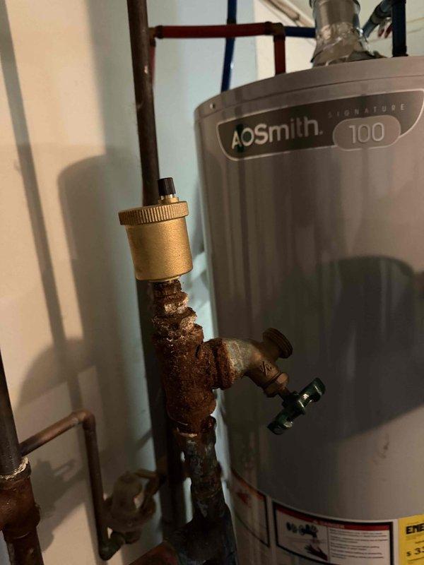 Performed follow-up service call to address corroded copper piping connected to recently installed A.O. Smith Signature 100 water heater. Inspected pressure gauge on system which showed proper reading despite significant oxidation on surrounding pipes. Verified all connections were secure and system was operating within normal parameters.