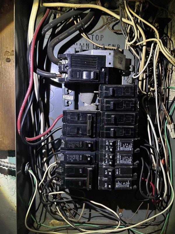 Conducted comprehensive assessment of existing electrical panel for AC replacement estimate. Documented current panel configuration, noting multiple breakers of varying sizes with somewhat disorganized wiring distribution. Evaluated available capacity and electrical infrastructure to determine compatibility with proposed new air conditioning system.