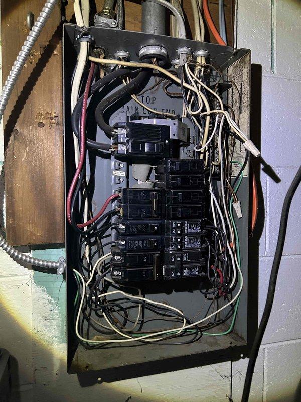 Conducted comprehensive assessment of existing electrical panel for AC replacement estimate. Documented current panel configuration, noting multiple breakers of varying sizes with somewhat disorganized wiring distribution. Evaluated available capacity and electrical infrastructure to determine compatibility with proposed new air conditioning system.