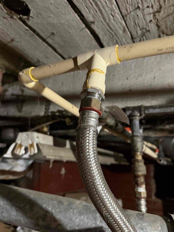 Responded to no water complaint following basement flooding. Inspected AO Smith water heater that customer was unable to restart after water receded. Found water supply connection intact with proper PVC and braided steel line connections, diagnosed pilot/ignition system issue, and successfully restored water heater operation and hot water service to residence.