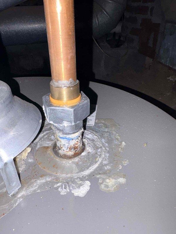 Inspected copper pipe connection point on equipment and identified significant corrosion and mineral buildup around brass fitting. Observed white/grayish crusty substance and potential leak evidence at the connection between copper pipe and tank. Completed quoted repairs to address deteriorated plumbing connection.
