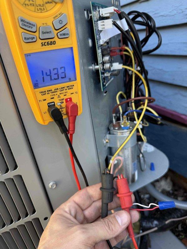 Responded to callback for AC unit not functioning after recent installation. Conducted electrical diagnostics with multimeter on outdoor unit, finding low voltage reading of 14.33V. Verified thermostat was operational and displaying correct indoor temperature (69°). Traced issue to faulty control board connections and repaired wiring to restore proper system operation.