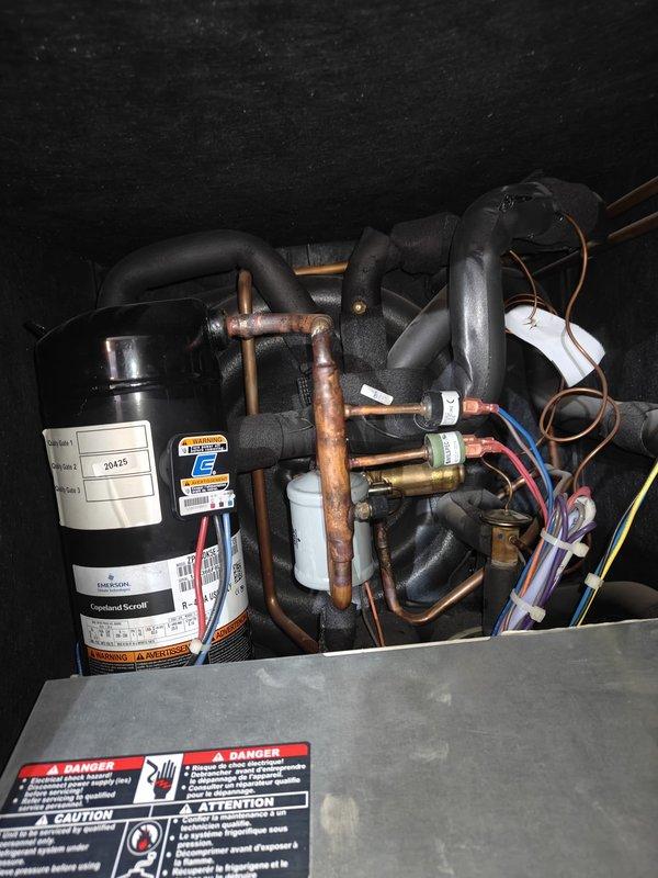 Performed routine cooling maintenance on a geothermal system. Conducted amperage testing on the compressor using a Fluke meter, confirming readings of 12 Amps AC which is within manufacturer specifications. Inspected refrigerant lines, pressure valves, and electrical connections throughout the system, ensuring all components were functioning properly.