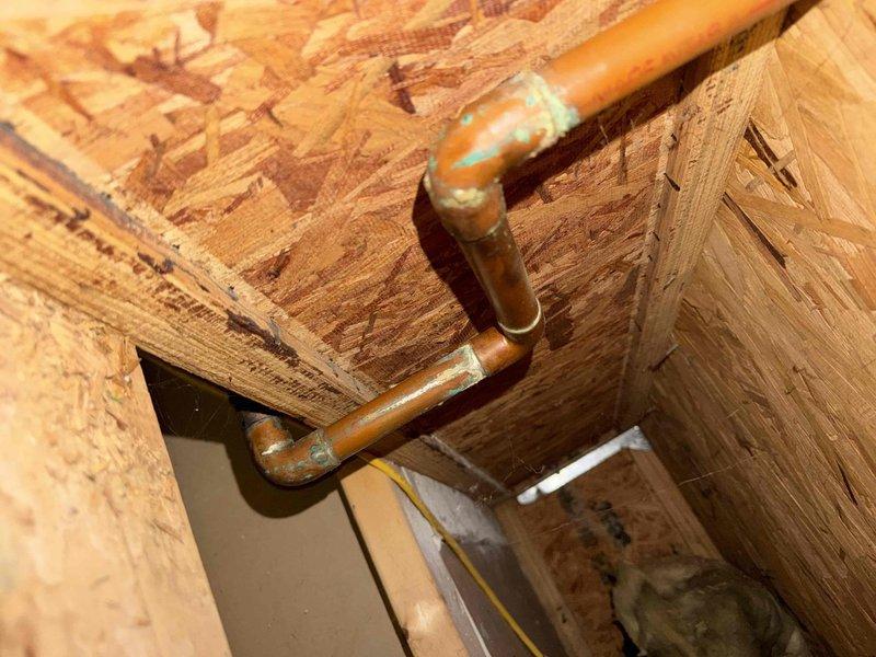 Investigated customer complaint of basement water damage after recent AC activation. Inspected air filtration system and found accumulated particulate matter on pleated filter. Examined copper plumbing configuration with 90-degree elbow joint, noting slight oxidation at soldered connection points where condensation appears to be originating.