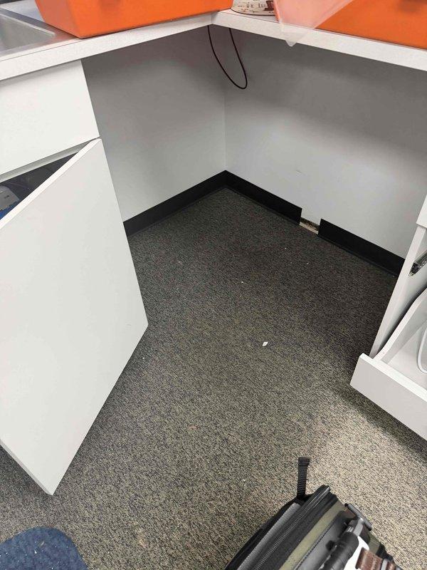 Responded to an emergency service call for commercial water leak at pharmacy following previous day's repair. Discovered significant water pooling on concrete floor with ceiling material debris present. Inspection revealed leak source in ceiling area above office workspace, requiring ladder access for complete repair and water extraction to prevent further damage to facility.