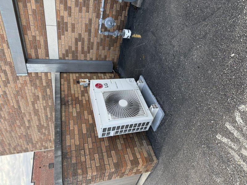 Conducted on-site assessment of existing LG mini-split system for potential replacement. Inspected outdoor condenser unit mounted on brick platform and examined interior components including filter mesh which showed normal dust accumulation. Documented current installation configuration and component conditions to prepare comprehensive replacement estimate.
