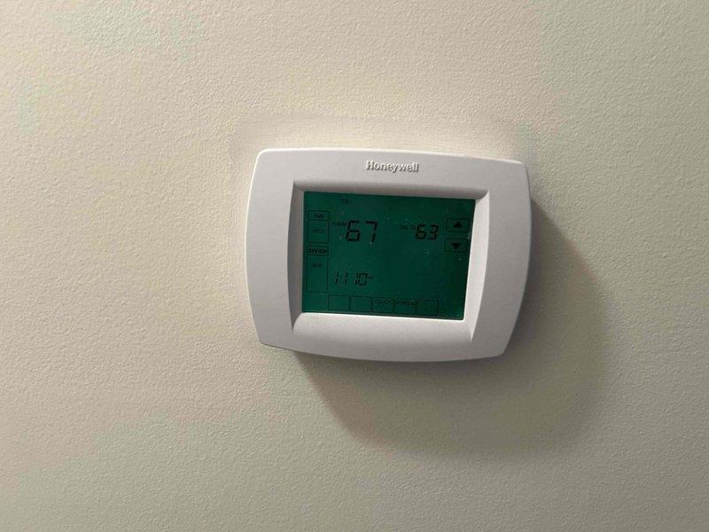 Conducted assessment of 15-year-old HVAC system requiring replacement. Inspected existing Honeywell digital thermostat (functioning properly) and evaluated outdoor AC unit showing signs of age-related wear. System has reached end of serviceable life and replacement recommended based on equipment condition and age.