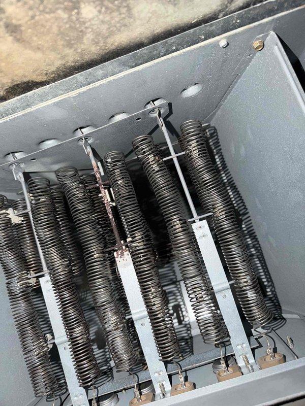 Performed assessment of heat pump air handler for removal to facilitate drywall replacement due to significant water damage. Inspection revealed deteriorated wall/ceiling junction with peeling paint, rotting wood, and visible water damage. Examination of HVAC components showed aging heating coils with discoloration and potential moisture exposure, requiring full system replacement as part of insurance claim.