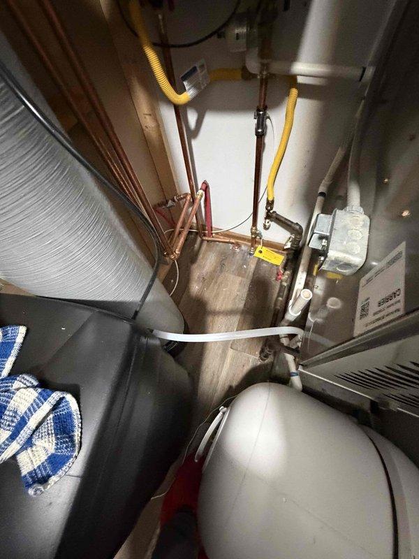 Responded to warranty service call for recently installed tankless water heater with reported leakage. Inspected copper piping connections and found minor leak at an elbow joint. Tightened connection and verified system integrity with no further water accumulation on floor.