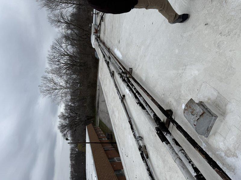 Conducted site assessment for replacement of 20-ton rooftop unit (RTU) in winter conditions. Inspected existing commercial HVAC equipment showing significant weathering, rust on support rails, and moisture damage. Documented current installation configuration and environmental factors to prepare comprehensive replacement estimate.