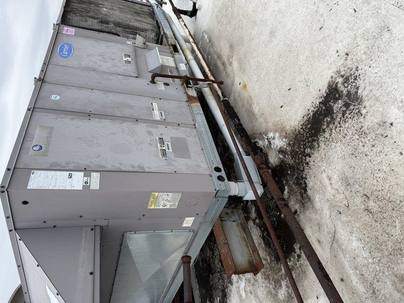 Conducted site assessment for replacement of 20-ton rooftop unit (RTU) in winter conditions. Inspected existing commercial HVAC equipment showing significant weathering, rust on support rails, and moisture damage. Documented current installation configuration and environmental factors to prepare comprehensive replacement estimate.