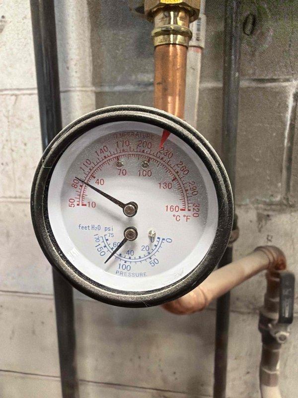 Responded to no-heat call for commercial customer. Diagnosed floor heating system failure due to cutout switch activation. Inspected boiler system and associated plumbing, noting proper operation of pressure/temperature gauge (reading 15-20 PSI at 10-20°C). Reset cutout switch and verified system returned to normal operation.