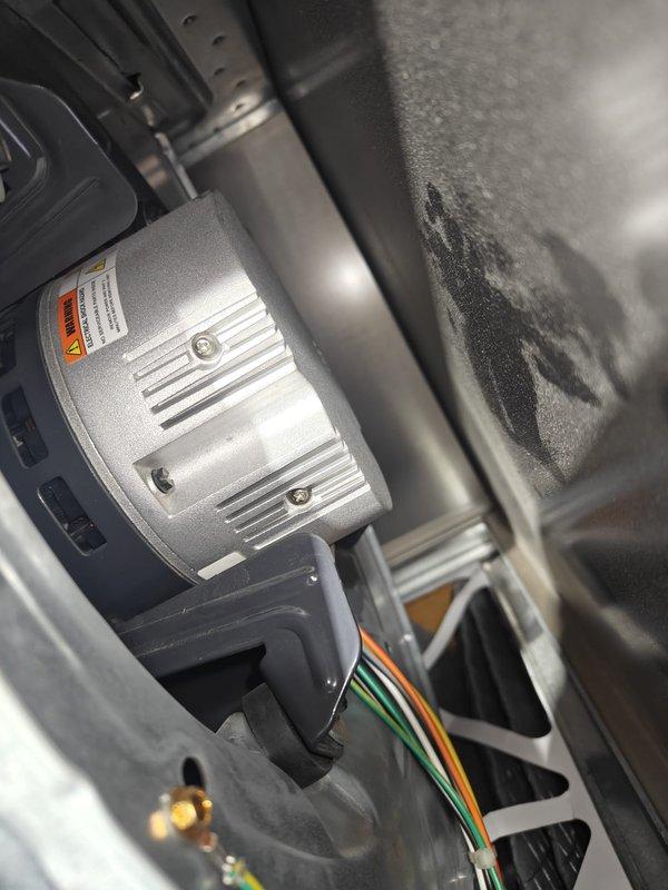 Completed annual heating maintenance on residential HVAC system. Performed comprehensive inspection of furnace cabinet and air handling unit, including blower motor assembly with heat dissipation fins and electrical connections. Verified proper operation of blower motor, inspected mounting hardware and warning labels for compliance. Examined multi-colored wire bundles and electrical connections for secure terminations and proper routing. Utilized clamp meter to measure electrical current draw, recording 0.5 amp reading to verify system performance within manufacturer specifications. Inspected galvanized ductwork and cabinet housing for structural integrity, noting normal dust accumulation consistent with system operation. All electrical connections secure, motor operating properly, and system tested successfully under load conditions.