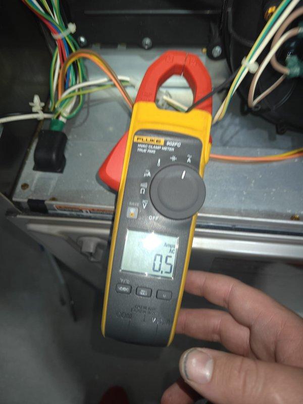 Completed annual heating maintenance on residential HVAC system. Performed comprehensive inspection of furnace cabinet and air handling unit, including blower motor assembly with heat dissipation fins and electrical connections. Verified proper operation of blower motor, inspected mounting hardware and warning labels for compliance. Examined multi-colored wire bundles and electrical connections for secure terminations and proper routing. Utilized clamp meter to measure electrical current draw, recording 0.5 amp reading to verify system performance within manufacturer specifications. Inspected galvanized ductwork and cabinet housing for structural integrity, noting normal dust accumulation consistent with system operation. All electrical connections secure, motor operating properly, and system tested successfully under load conditions.