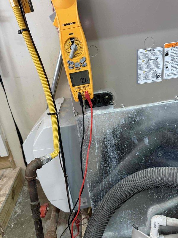 Completed comprehensive heating system maintenance inspection and diagnostics. Utilized clamp meter to verify electrical parameters and amp draw on blower motor assembly, confirming proper operation within manufacturer specifications. Inspected HVAC unit housing, noting visible wear and corrosion on exterior panels with rust formation along metal edges and deteriorated paint finish. Examined blower assembly compartment, observing significant dust and particulate accumulation on cylindrical blower housing requiring attention. Verified all flexible duct connections and conduit routing for proper installation. Documented equipment condition with photographic evidence showing age-related deterioration of cabinet components and need for future consideration of panel replacement or refinishing to prevent further corrosion. All electrical connections tested and found secure. System operational and ready for heating season.