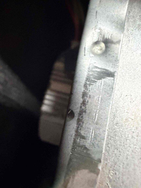 Completed comprehensive heating system maintenance inspection and diagnostics. Utilized clamp meter to verify electrical parameters and amp draw on blower motor assembly, confirming proper operation within manufacturer specifications. Inspected HVAC unit housing, noting visible wear and corrosion on exterior panels with rust formation along metal edges and deteriorated paint finish. Examined blower assembly compartment, observing significant dust and particulate accumulation on cylindrical blower housing requiring attention. Verified all flexible duct connections and conduit routing for proper installation. Documented equipment condition with photographic evidence showing age-related deterioration of cabinet components and need for future consideration of panel replacement or refinishing to prevent further corrosion. All electrical connections tested and found secure. System operational and ready for heating season.