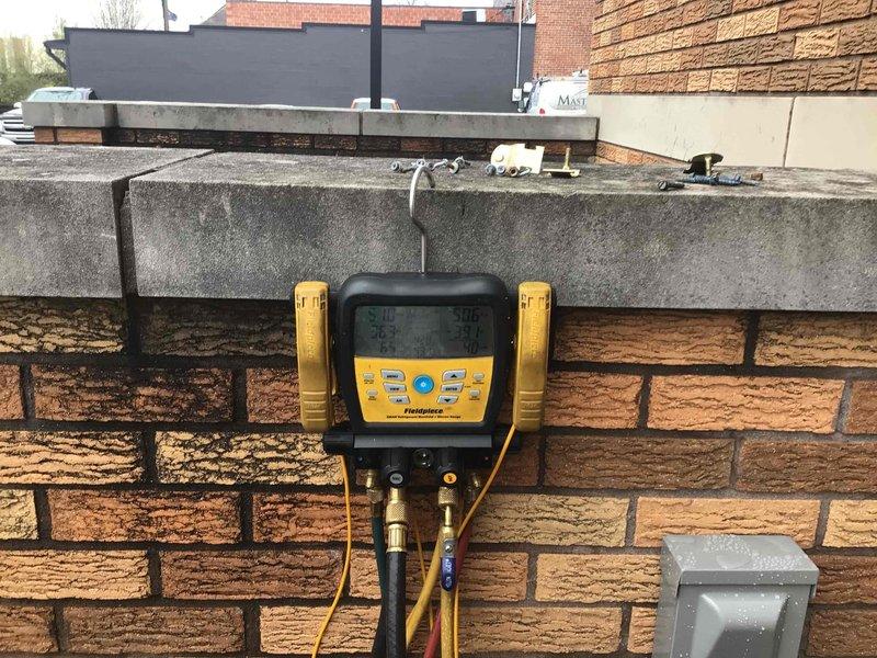 Completed installation of line hide system for wall-mounted mini-split air conditioning unit. Concealed refrigerant lines and electrical wiring from indoor head unit through drop ceiling opening, ensuring clean professional appearance. Verified system operation and proper refrigerant levels using diagnostic manifold gauges at outdoor rooftop equipment location.