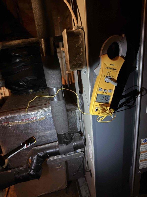 Responded to no cooling complaint with system blowing warm air. Performed diagnostic evaluation of outdoor condensing unit and indoor air handler. Found capacitor showing signs of corrosion and age-related deterioration with rust visible on terminals. Measured system amperage at 7.58 amps using clamp meter to verify compressor operation and electrical performance. Inspected contactor, wiring connections, and electrical components for proper function and identified need for capacitor replacement due to visible deterioration affecting system performance.