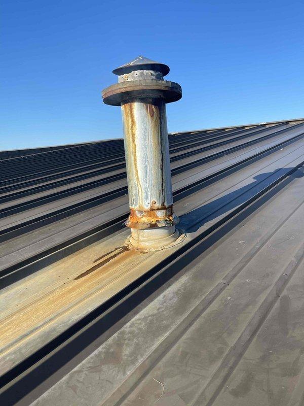 Responded to no heat callback on commercial rooftop unit. Upon arrival, inspected heating system and found unit would not maintain operation when thermostat override was attempted. Performed diagnostic evaluation of rooftop equipment, examined vent stack and flashing assembly which showed significant rust corrosion and weathering at roof penetration point. Documented existing conditions of exhaust vent pipe and rain cap assembly with visible deterioration affecting system components. Unit requires further assessment to determine root cause of recurring heating failure and restore reliable operation.