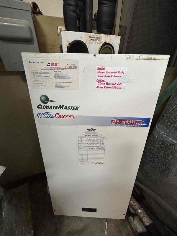 Conducted comprehensive assessment of 25-year-old ClimateMaster WaterFurnace Premier geothermal heat pump system for replacement evaluation. Unit exhibited age-related deterioration including surface corrosion on mounting hardware, rust staining around connection points, and general wear consistent with extended service life. Documented existing installation configuration including black flexible ductwork connections, electrical service components, and mechanical room layout. Photographed unit specifications, service history labels, and existing infrastructure to develop accurate replacement proposal for new geothermal system.