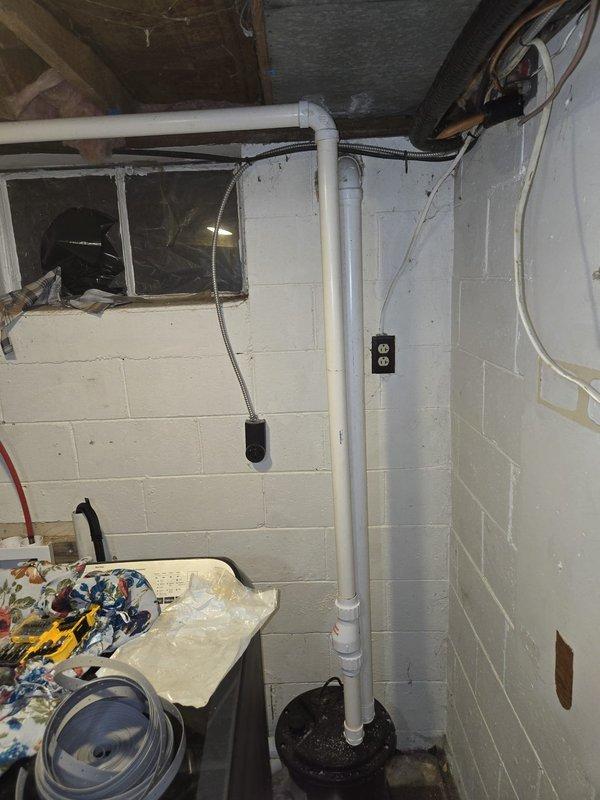 Completed full HVAC system installation in basement utility area. Installed new condensate drain line using white PVC piping with proper vertical routing from ceiling to floor-mounted drain fitting, secured all plumbing connections, and ran electrical wiring with appropriate conduit and outlet boxes to support new equipment. Verified all mechanical systems operational, ensured proper drainage flow, and completed financing paperwork per customer request.