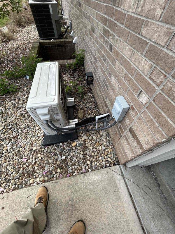 Conducted on-site evaluation for mini-split system installation at residential property. Assessed existing exterior HVAC equipment placement and electrical infrastructure, including conduit routing and junction box location along brick exterior wall. Evaluated interior installation requirements for wall-mounted air handler unit, confirming adequate wall space and clearances in room with existing skylight and laminate flooring.