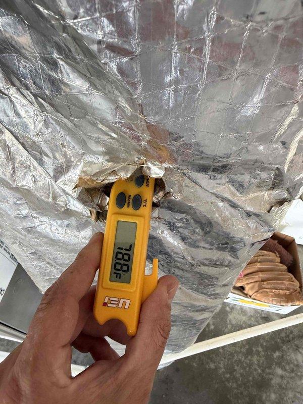 Responded to no cooling complaint on new HVAC system. Upon inspection, discovered supply plenum had inadequate or improperly sealed duct connection at the circular trunk line transition. Measured and verified airflow deficiency using digital instrumentation at the ductwork interface where metallic flex duct showed visible separation and compromised sealing at the plenum chamber. Identified that insufficient airflow distribution was caused by the disconnected or poorly fitted duct connection preventing conditioned air from reaching living spaces. Corrected the duct connection, ensuring proper seating and sealed all joints at the plenum transition point to restore full system airflow and cooling capacity.