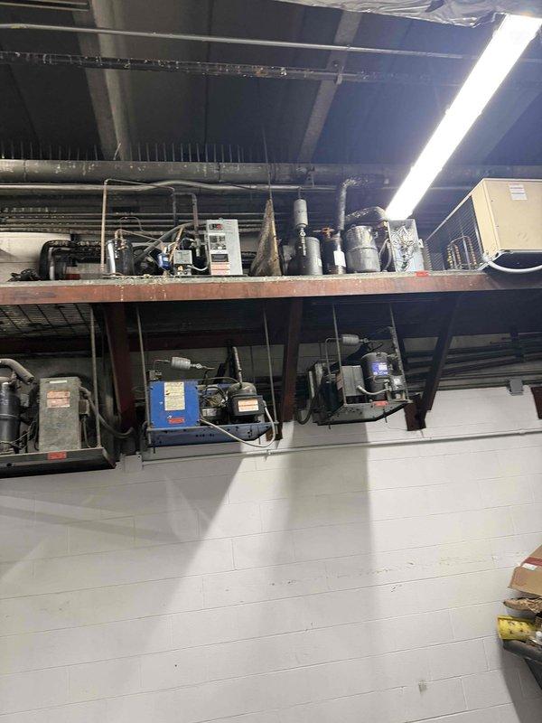 Responded to no cooling complaint at commercial facility. Performed diagnostic evaluation of multi-compressor HVAC system mounted on elevated platform with associated ductwork and refrigeration components. Documented equipment condition and configuration including multiple compressor units, refrigerant lines, and control systems. Provided comprehensive assessment of system status and presented repair versus replacement options to management for decision-making purposes.