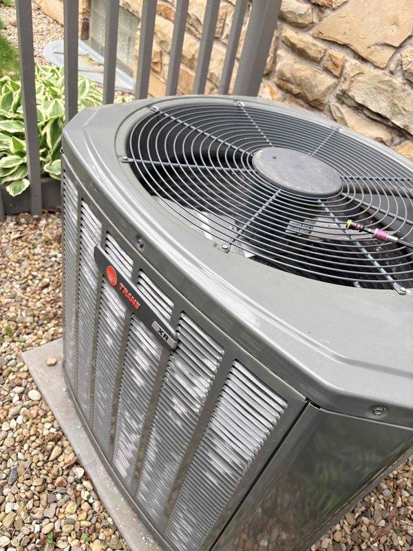 Responded to no cooling complaint with buzzing noise at condenser unit. Upon arrival, found Trane outdoor condensing unit inoperative with audible buzzing from compressor attempting to start. Diagnosed failed run capacitor preventing compressor from starting properly. Removed defective capacitor showing visible corrosion and terminal deterioration. Replaced capacitor with proper OEM equivalent, verified correct microfarad rating and voltage specifications. Cycled system through complete cooling cycle, confirmed compressor started smoothly without buzzing, verified proper amp draw on compressor and condenser fan motor, and confirmed adequate airflow through condenser coil. System restored to normal cooling operation.