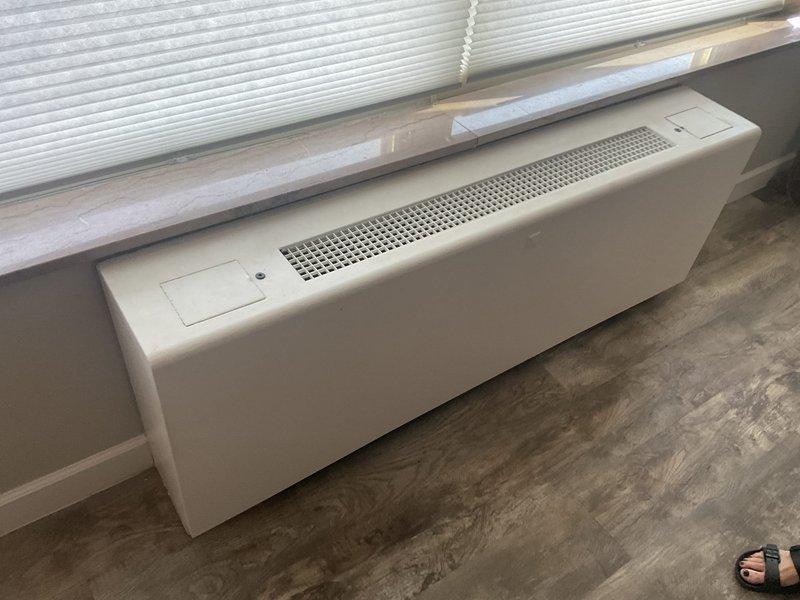 Responded to service call for non-operational boiler heating system in condo unit that failed at end of previous season. Performed diagnostic inspection of baseboard heating unit and boiler-chilled AC system. Documented existing equipment condition with photos showing baseboard heater installation and evidence of significant water damage on flooring near HVAC components, which may require further investigation to determine impact on system performance.