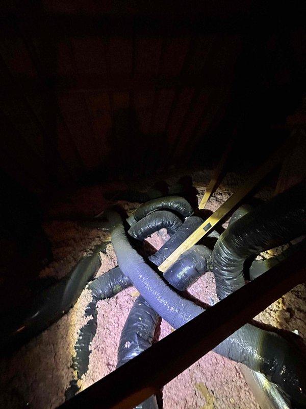 Conducted attic inspection and system evaluation for full HVAC replacement estimate at customer's specific request. Accessed attic space via ladder to assess existing equipment, flexible black ductwork installation, and pink fiberglass insulation throughout the space. Documented current system configuration with photographs, including measurements of ductwork routing across wooden joists, electronic control components mounted to structural beams, and metallic cylindrical duct sections with flexible ribbed construction. Provided comprehensive replacement estimate based on attic-mounted system assessment and existing infrastructure conditions.
