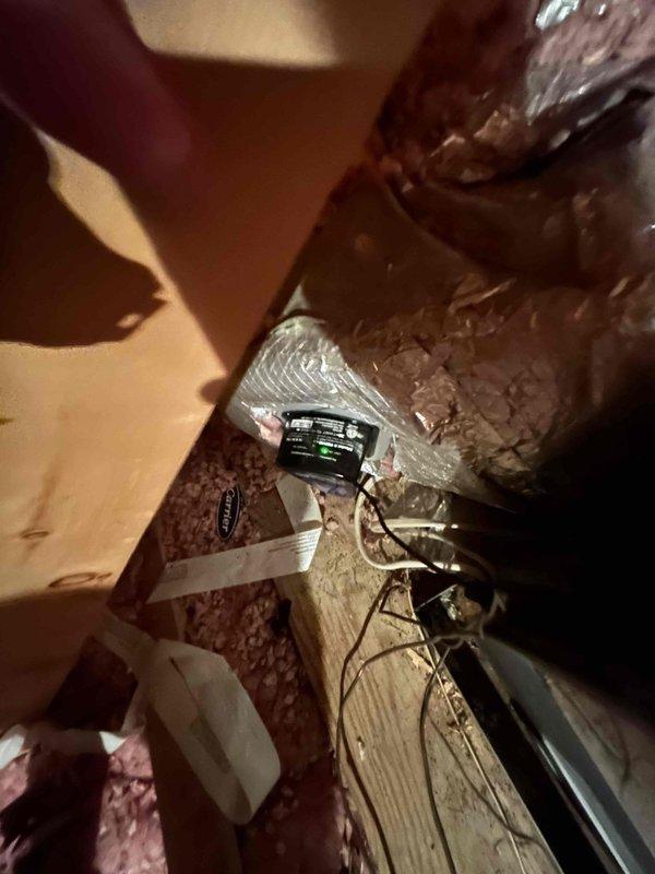 Conducted attic inspection and system evaluation for full HVAC replacement estimate at customer's specific request. Accessed attic space via ladder to assess existing equipment, flexible black ductwork installation, and pink fiberglass insulation throughout the space. Documented current system configuration with photographs, including measurements of ductwork routing across wooden joists, electronic control components mounted to structural beams, and metallic cylindrical duct sections with flexible ribbed construction. Provided comprehensive replacement estimate based on attic-mounted system assessment and existing infrastructure conditions.