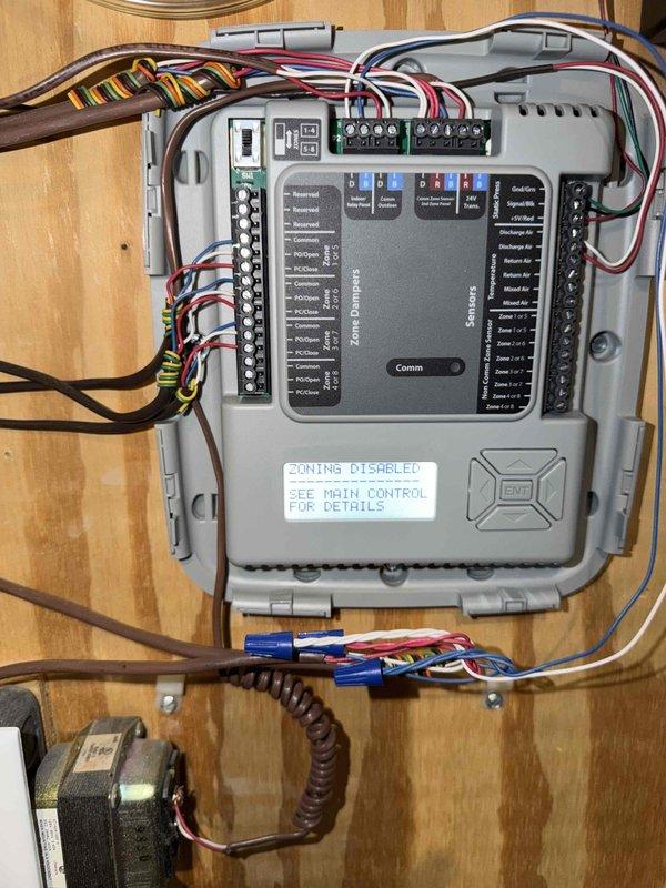 Responded to no cooling call where unit was displaying error codes at both the equipment and thermostat. Upon arrival, found zone damper control system showing "ZONING DISABLED" status with notification to check main control for details. Inspected zone damper control board, associated transformers, and low-voltage wiring connections throughout the system. Documented electrical panel configuration including GFCI outlet, dual transformers, and multi-zone wiring terminations to identify source of communication failure between zoning system and HVAC equipment.