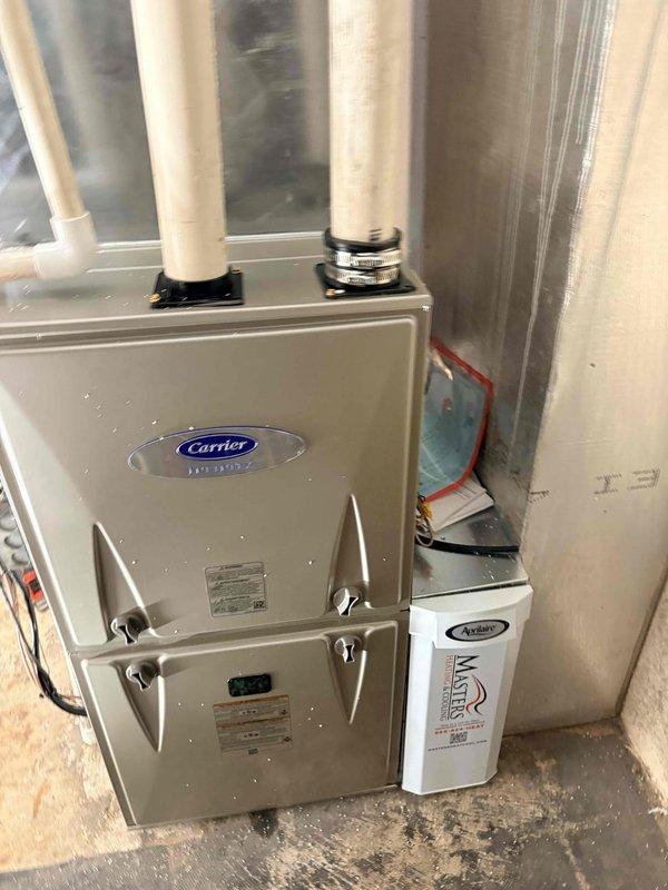 Completed full HVAC system installation in residential basement utility room, including Carrier brand furnace unit with proper venting configuration. Installed white PVC intake and exhaust pipes extending from unit top, secured with mounting brackets per manufacturer specifications. Integrated REME HALO air purification system mounted to furnace cabinet with appropriate electrical connections. Connected all ductwork and verified proper airflow throughout system. Obtained required financing paperwork signatures and discussed extended maintenance plan options with homeowner, who declined due to future home sale plans within four years.