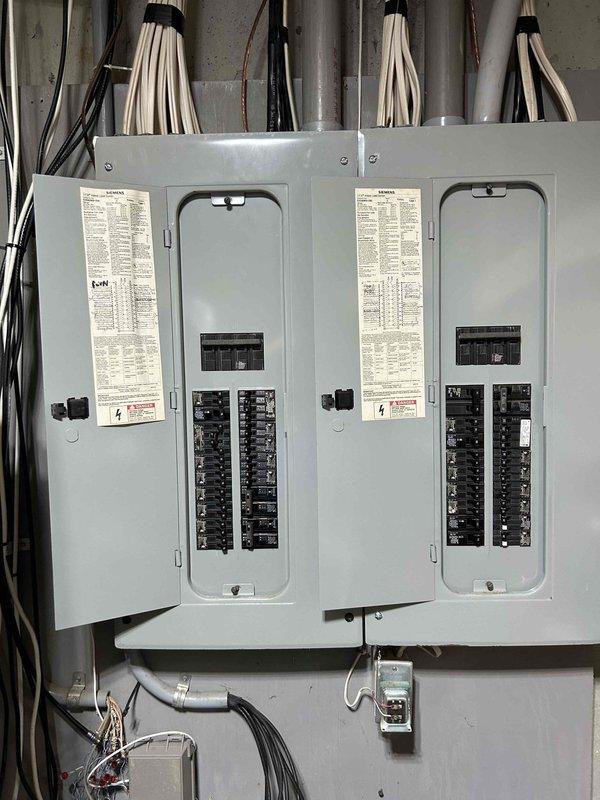 Conducted comprehensive site evaluation for HVAC system replacement at residential property. Assessed existing dual outdoor condenser unit configuration, including refrigerant line routing, electrical disconnect, and mounting pad condition. Documented current electrical service panel capacity with three-panel array to verify adequate power supply for potential full system upgrade. Evaluated feasibility of complete air conditioning replacement versus full heating and cooling system installation based on existing infrastructure and electrical service capabilities.