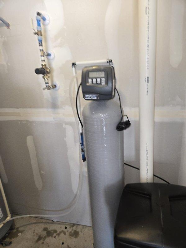 Inspected residential mechanical room and documented existing equipment installations. Verified proper operation of A.O. Smith ProMax water heater with connected PEX supply lines, expansion tank, and temperature/pressure relief valve. Confirmed water treatment system including softener unit with digital control head and multi-stage filtration system are functioning as designed per quote specifications.