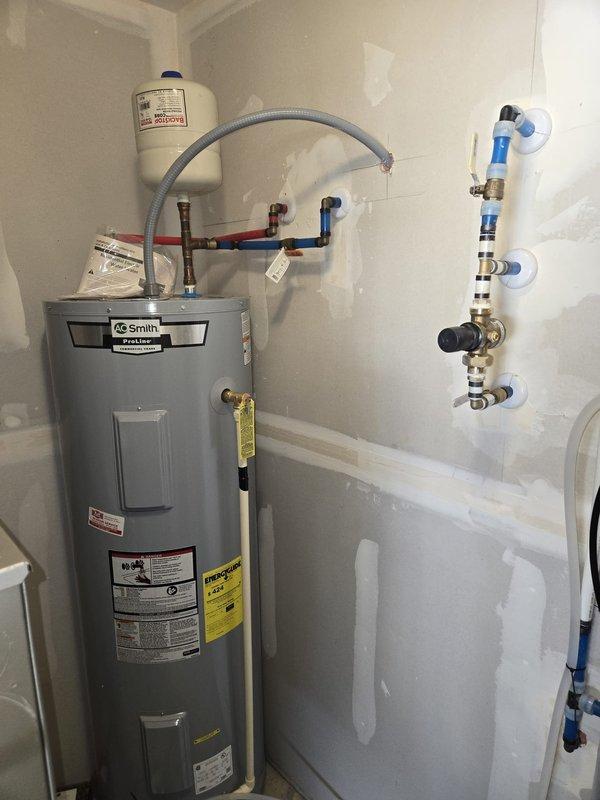 Inspected residential mechanical room and documented existing equipment installations. Verified proper operation of A.O. Smith ProMax water heater with connected PEX supply lines, expansion tank, and temperature/pressure relief valve. Confirmed water treatment system including softener unit with digital control head and multi-stage filtration system are functioning as designed per quote specifications.
