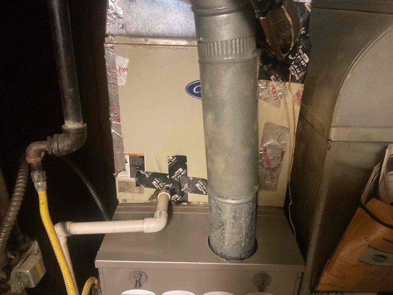 Responded to warranty service call for condenser fan motor replacement. Upon arrival, confirmed motor failure and verified warranty coverage. Required replacement part was unavailable on truck and located in shop inventory. Documented existing HVAC system installation in basement mechanical space, including ductwork configuration, furnace unit, and associated plumbing connections for service records.