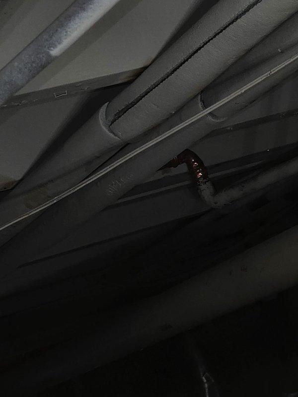 Responded to service call for boiler system modifications due to exposed kitchen ceiling from water damage incident. Performed diagnostic assessment of boiler piping system, specifically evaluating the hydronic supply line running from boiler to upstairs bathroom radiator and identifying downstairs radiator for removal. Inspected existing copper and PEX piping infrastructure in exposed ceiling cavity, documented current configuration of heating distribution system including insulated supply lines, return piping, and support brackets. Assessed condition of piping connections, hangers, and insulation material throughout affected area. Provided customer with evaluation of required repairs to bathroom heating line and scope of work for radiator removal from downstairs zone.