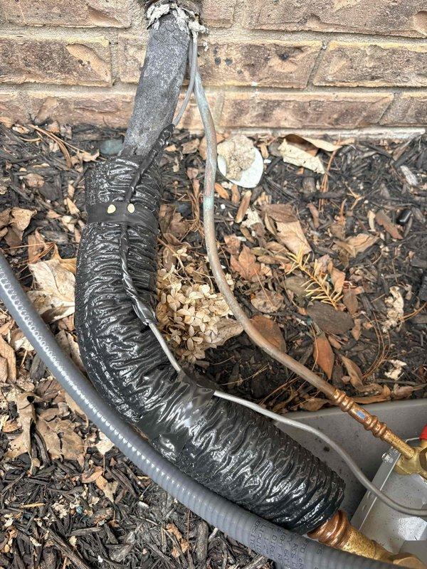 Responded to callback regarding exposed wiring visible at exterior installation site. Inspected refrigerant line set with black insulation wrap and associated electrical wiring running along foundation near wall penetration. Secured and properly concealed exposed control wiring in conduit to address safety concerns and ensure installation meets code requirements.