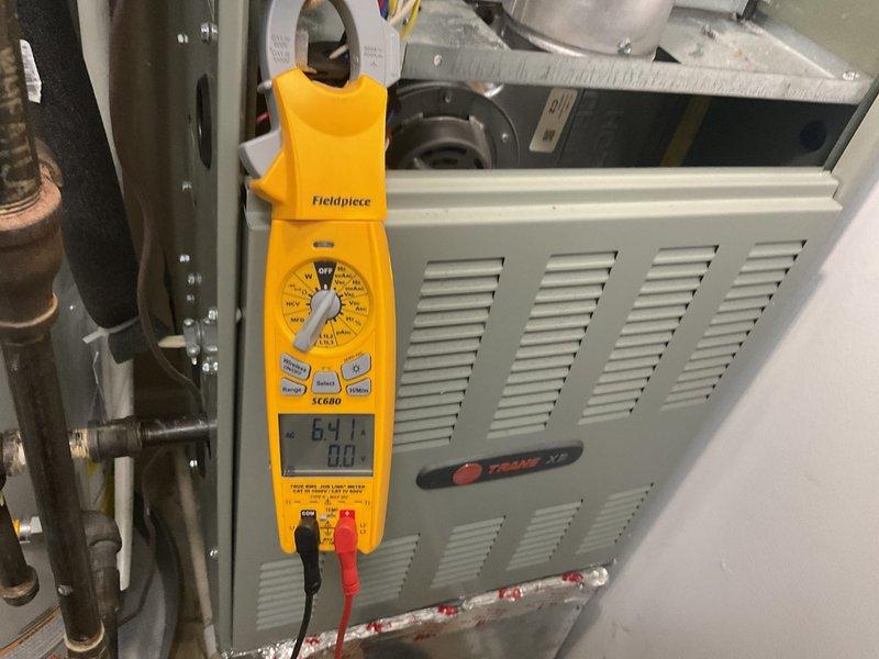 Completed comprehensive cooling maintenance on Trane HVAC system including inspection of furnace unit, air handler, and outdoor condensing unit. Performed electrical diagnostics using digital clamp meter, verified amperage readings at 64.1 amps, and inspected refrigerant line insulation for proper coverage. Checked condensate pump operation and drainage system functionality, ensuring all components operating within manufacturer specifications for optimal cooling season performance.