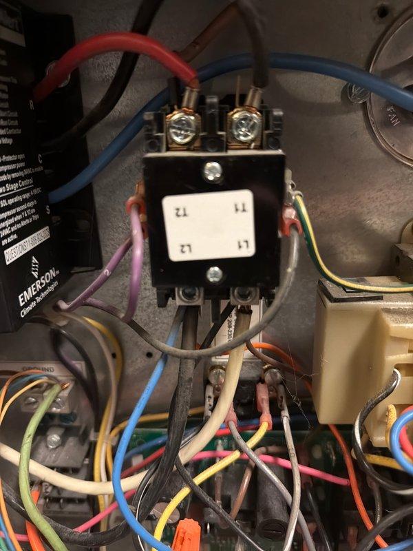 Completed 2026 cooling first service on geothermal HVAC system. Inspected electrical control panel, verified contactor operation and terminal connections, examined control module and capacitor functionality, and documented system components with photos. All electrical connections found secure with proper wire terminations to contactor terminals L1, L2, T1, and T2.