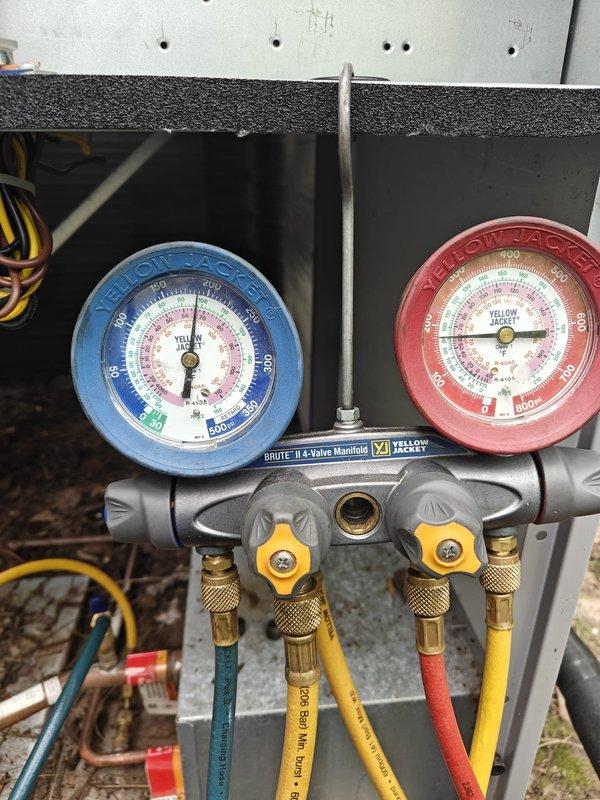 Performed comprehensive leak search on HVAC system using manifold gauge set to diagnose refrigerant loss. Inspected corroded refrigerant lines and fittings, including sight glass assembly showing significant oxidation and deterioration. System pressures monitored and documented; identified areas of concern requiring further evaluation due to advanced corrosion on piping components and brass fittings.