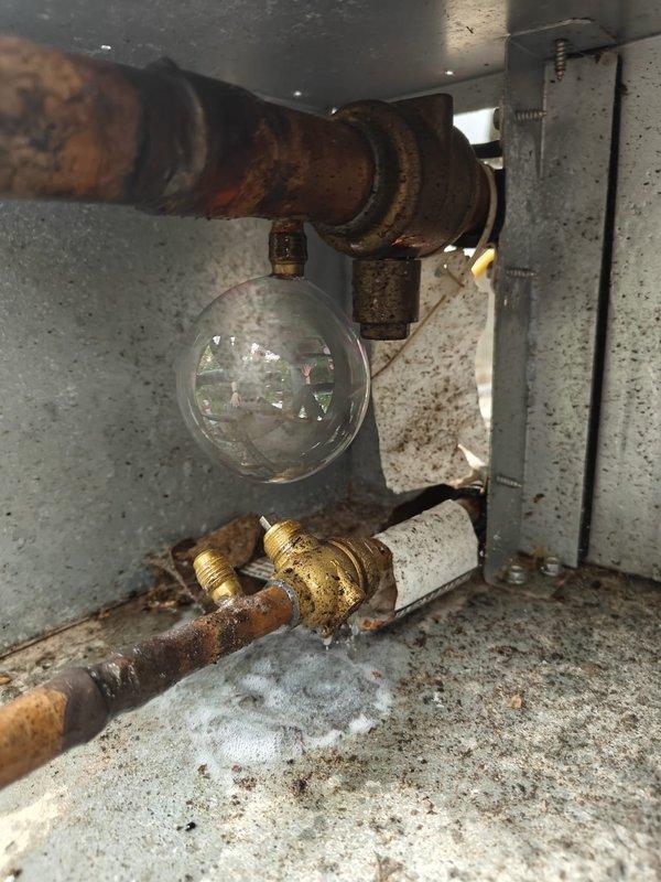 Performed comprehensive leak search on HVAC system using manifold gauge set to diagnose refrigerant loss. Inspected corroded refrigerant lines and fittings, including sight glass assembly showing significant oxidation and deterioration. System pressures monitored and documented; identified areas of concern requiring further evaluation due to advanced corrosion on piping components and brass fittings.